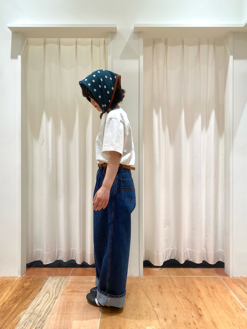 ブルー系のデニムパンツ、ホワイト系のTシャツ/カットソー、ブラウン系のベルトを着用したレディースの夏コーディネートの2枚目の写真