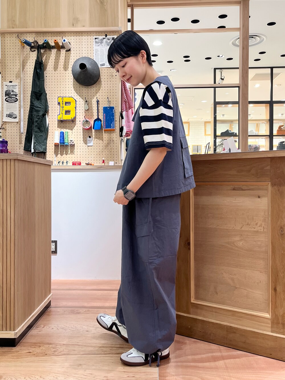 グレー系のベスト、グレー系のその他パンツ、ブルー系のTシャツ/カットソーを着用したレディースの春コーディネートの2枚目の写真