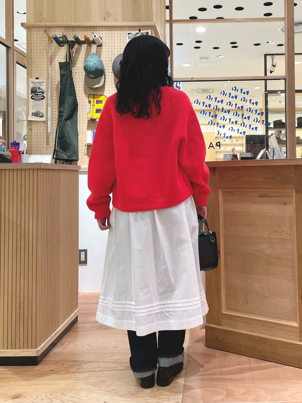 オレンジ系のカーディガン/ボレロ、ブルー系のTシャツ/カットソー、ホワイト系のスカートを着用したレディースの秋コーディネートの3枚目の写真