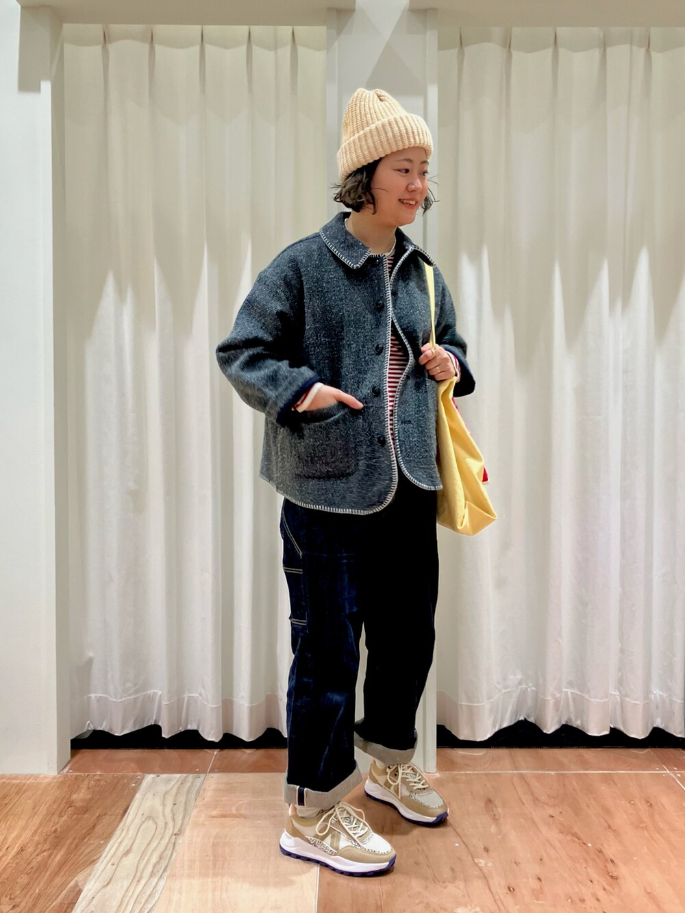 グリーン系のブルゾン、レッド系のTシャツ/カットソー、イエロー系のトートバッグを着用したレディースの冬コーディネートの2枚目の写真