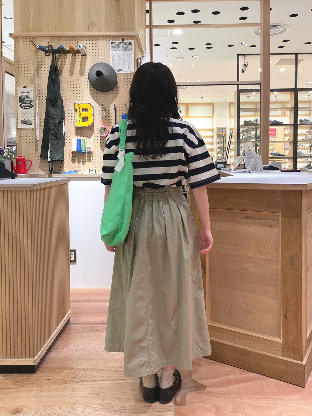 ベージュ系のスカート、ブルー系のTシャツ/カットソーを着用したレディースの春コーディネートの3枚目の写真