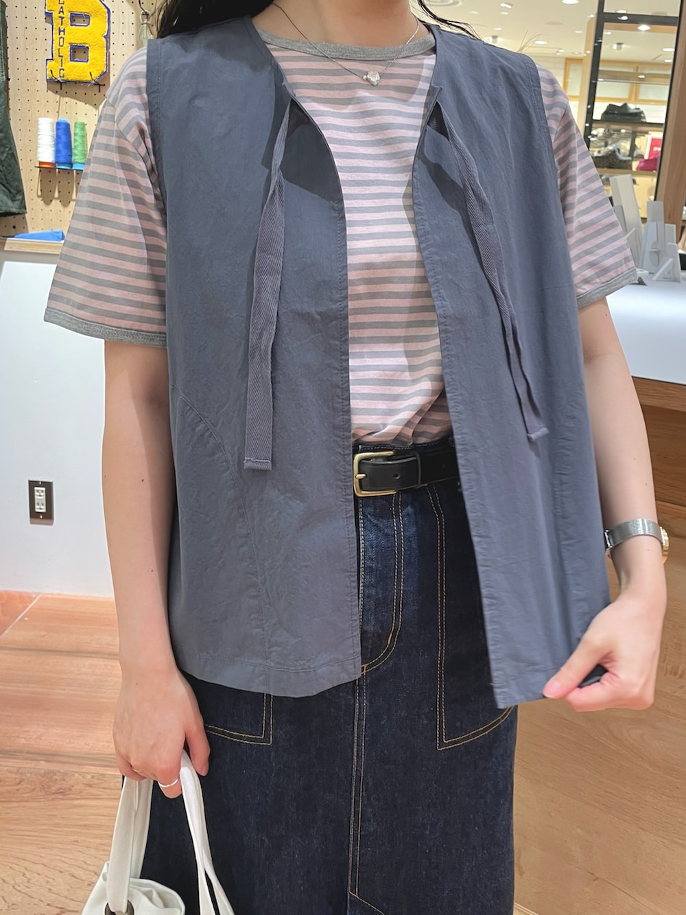 ブルー系のデニムスカート、ホワイト系のトートバッグ、ピンク系のTシャツ/カットソーを着用したレディースの夏コーディネートの3枚目の写真
