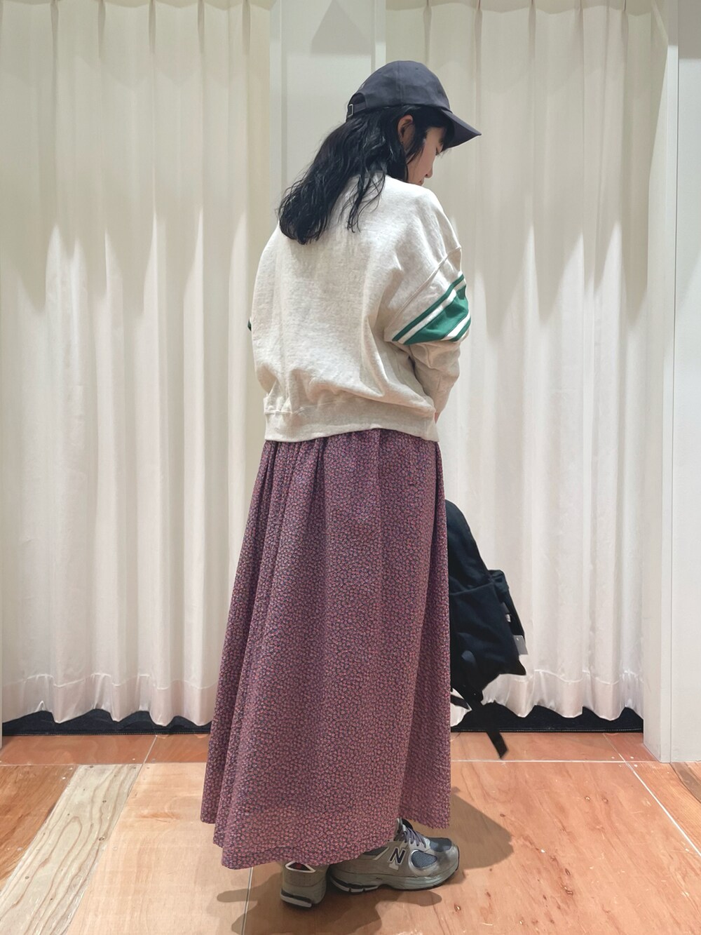 レッド系のスカート、ホワイト系のスウェットを着用したレディースの冬コーディネートの3枚目の写真