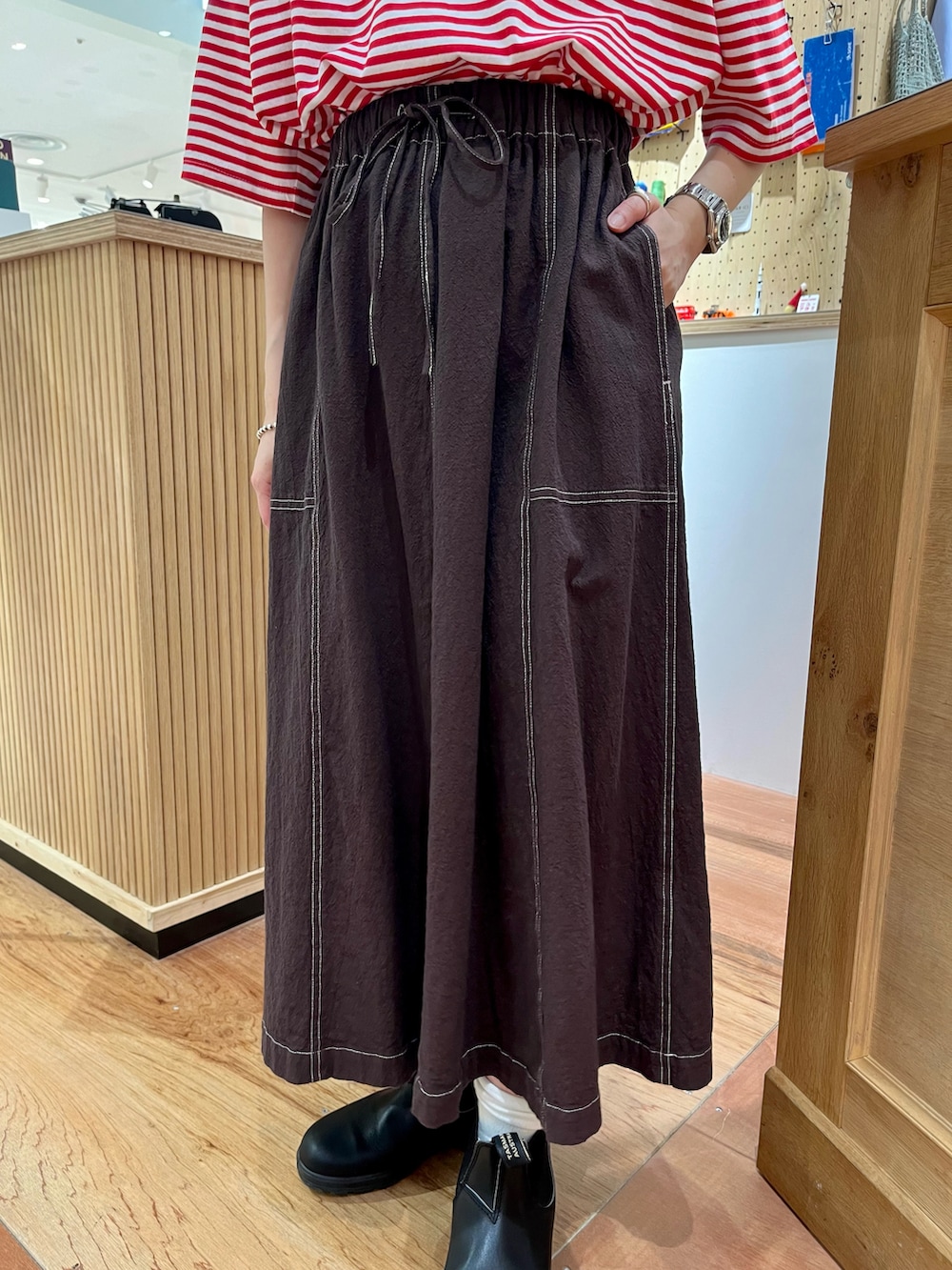 レッド系のTシャツ/カットソー、ブラウン系のスカートを着用したレディースの夏コーディネートの5枚目の写真