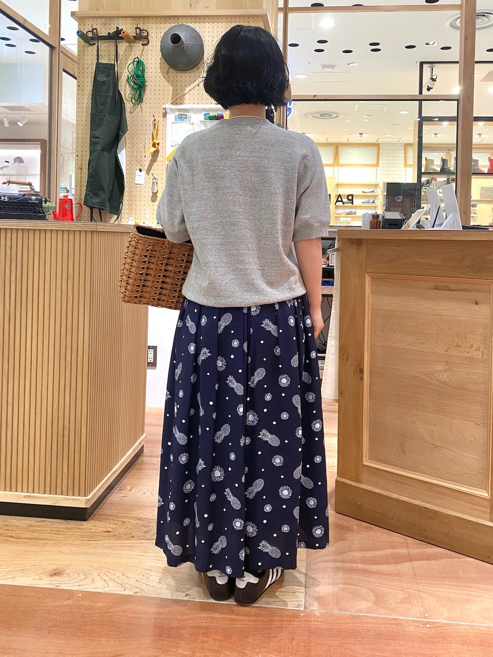 ブルー系のスカート、グレー系のTシャツ/カットソー、ホワイト系のネックレスを着用したレディースの夏コーディネートの3枚目の写真