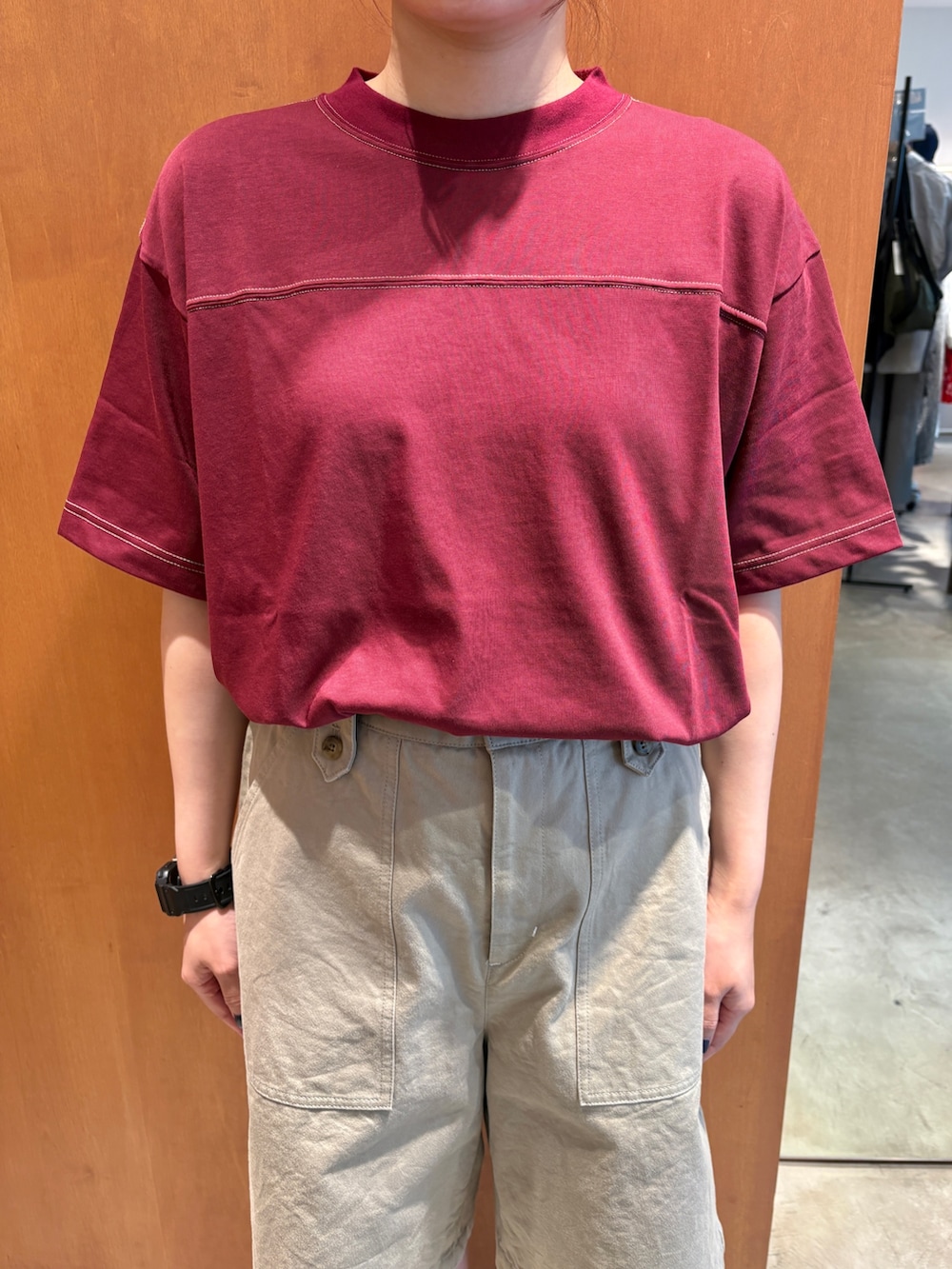 レッド系のTシャツ/カットソー、ベージュ系のチノパンツ、ブラック系のベルトを着用したレディースの夏コーディネートの4枚目の写真