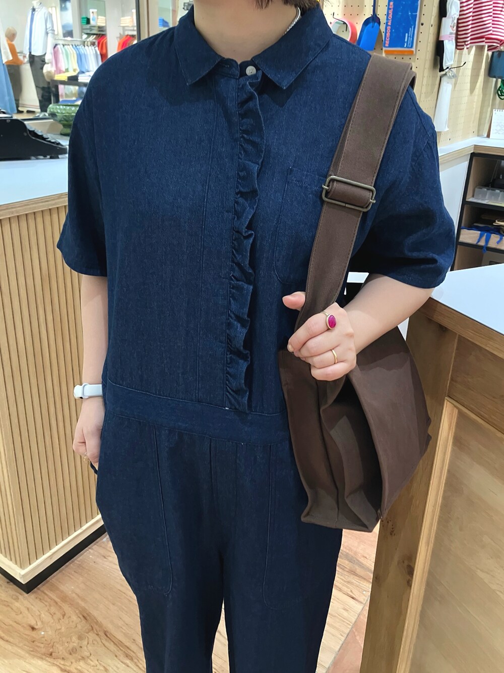 ブルー系のつなぎ/オールインワン、ブラウン系のショルダーバッグ、ホワイト系のタンクトップを着用したレディースの春コーディネートの4枚目の写真