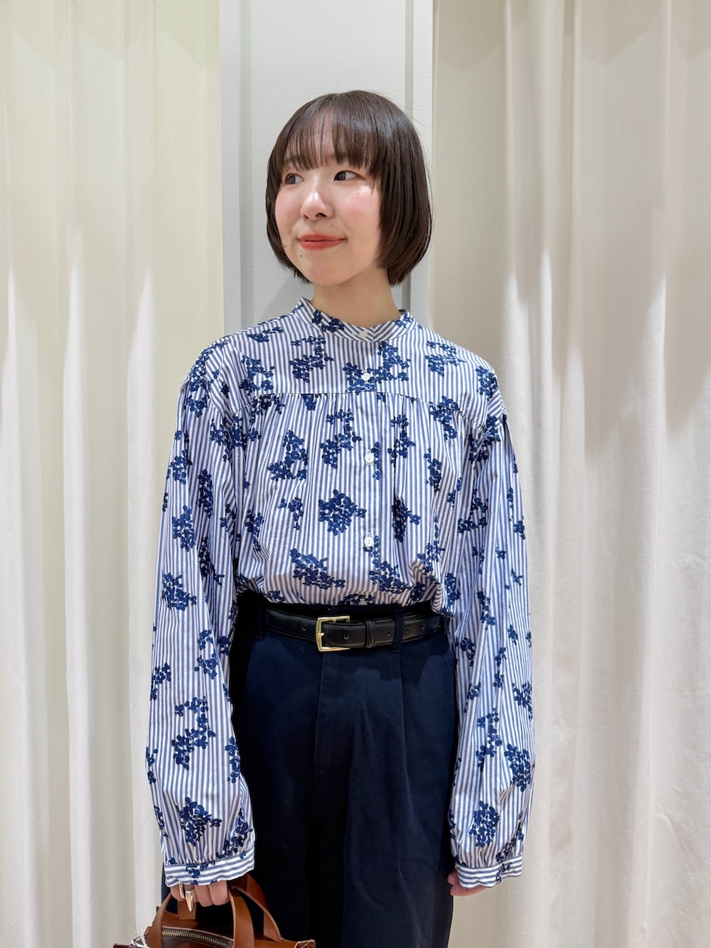 ブルー系のシャツ/ブラウス、ブルー系のチノパンツ、ブラウン系のショルダーバッグを着用したレディースの春コーディネートの4枚目の写真