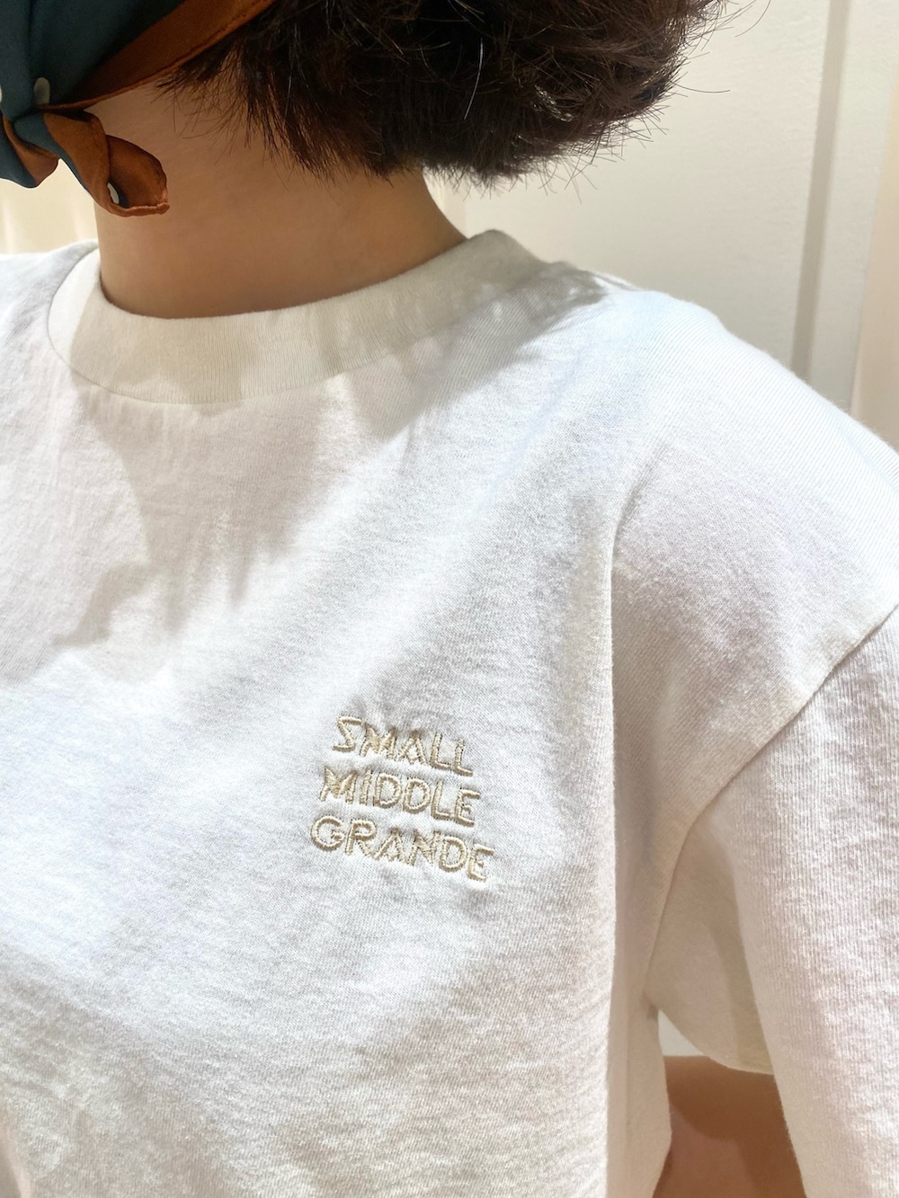 ブルー系のデニムパンツ、ホワイト系のTシャツ/カットソー、ブラウン系のベルトを着用したレディースの夏コーディネートの6枚目の写真