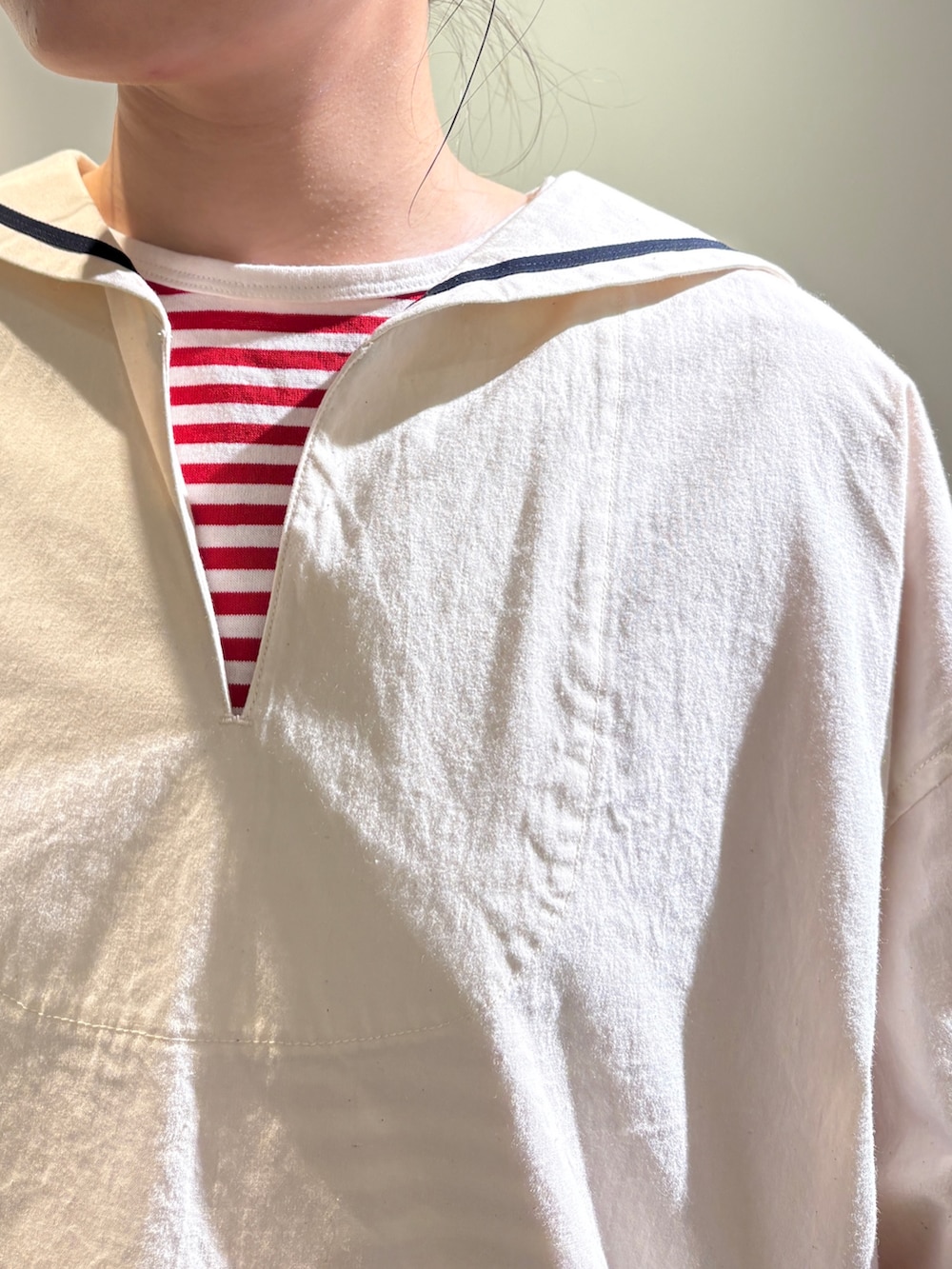 ホワイト系のシャツ/ブラウス、レッド系のTシャツ/カットソー、ベージュ系のチノパンツを着用したレディースの夏コーディネートの4枚目の写真