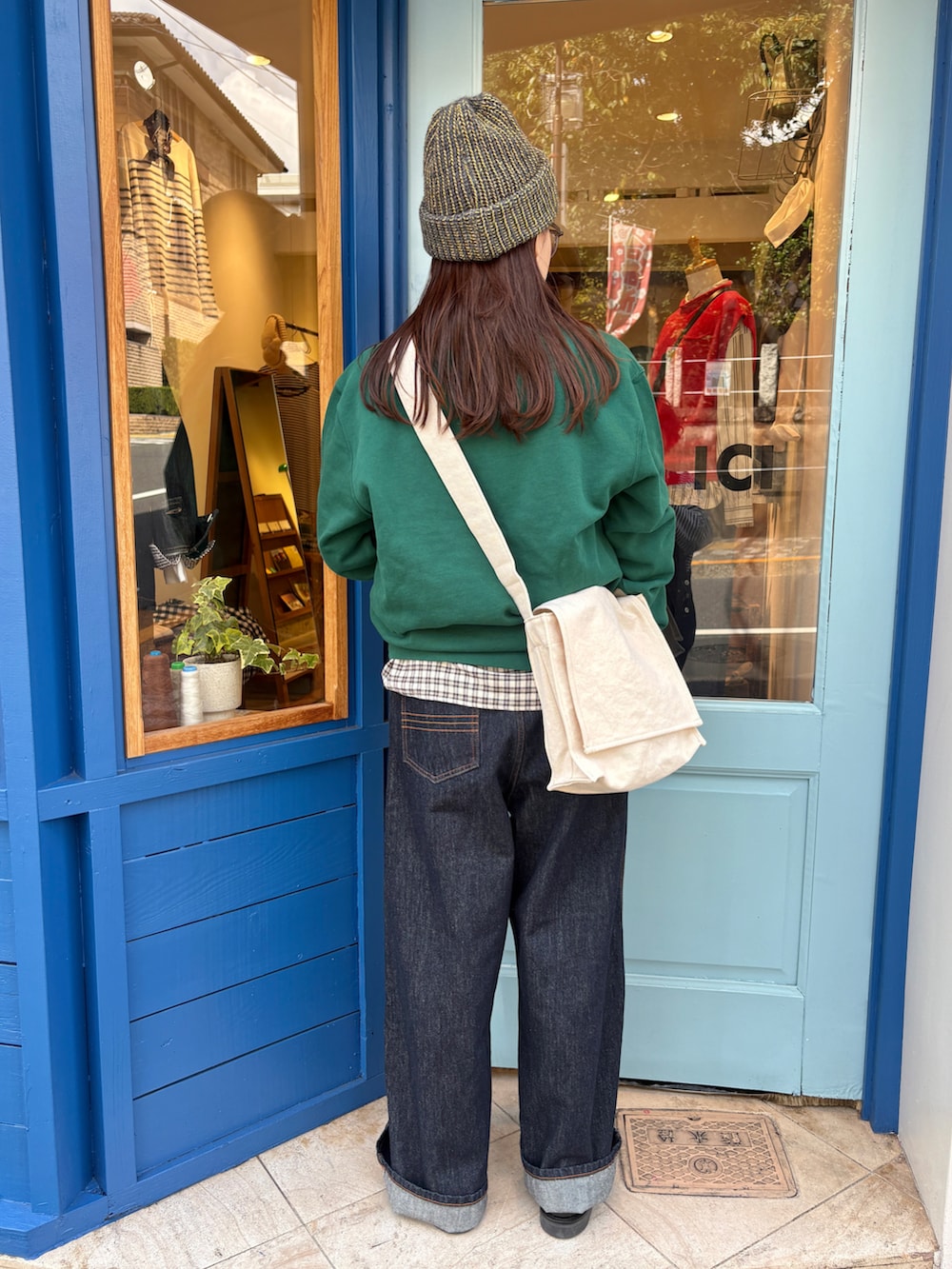 グリーン系のスウェット、ブルー系のシャツ/ブラウス、ブルー系のデニムパンツを着用したレディースの秋コーディネートの3枚目の写真