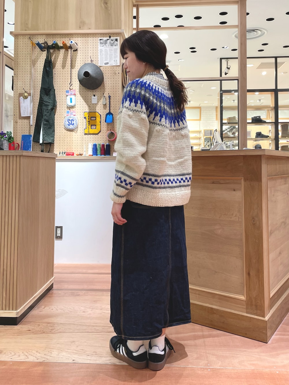 ホワイト系のカーディガン/ボレロ、グレー系のシャツ/ブラウス、ブルー系のデニムスカートを着用したレディースの秋コーディネートの4枚目の写真