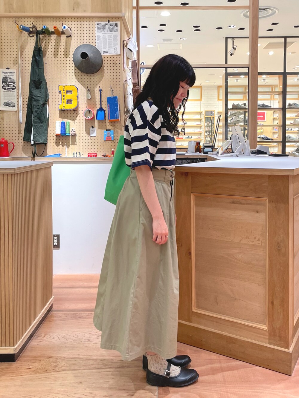 ベージュ系のスカート、ブルー系のTシャツ/カットソーを着用したレディースの春コーディネートの2枚目の写真