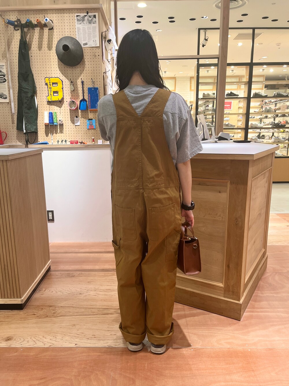 ブラウン系のサロペット/オーバーオール、ホワイト系のシャツ/ブラウス、グレー系のTシャツ/カットソーを着用したレディースの春コーディネートの4枚目の写真