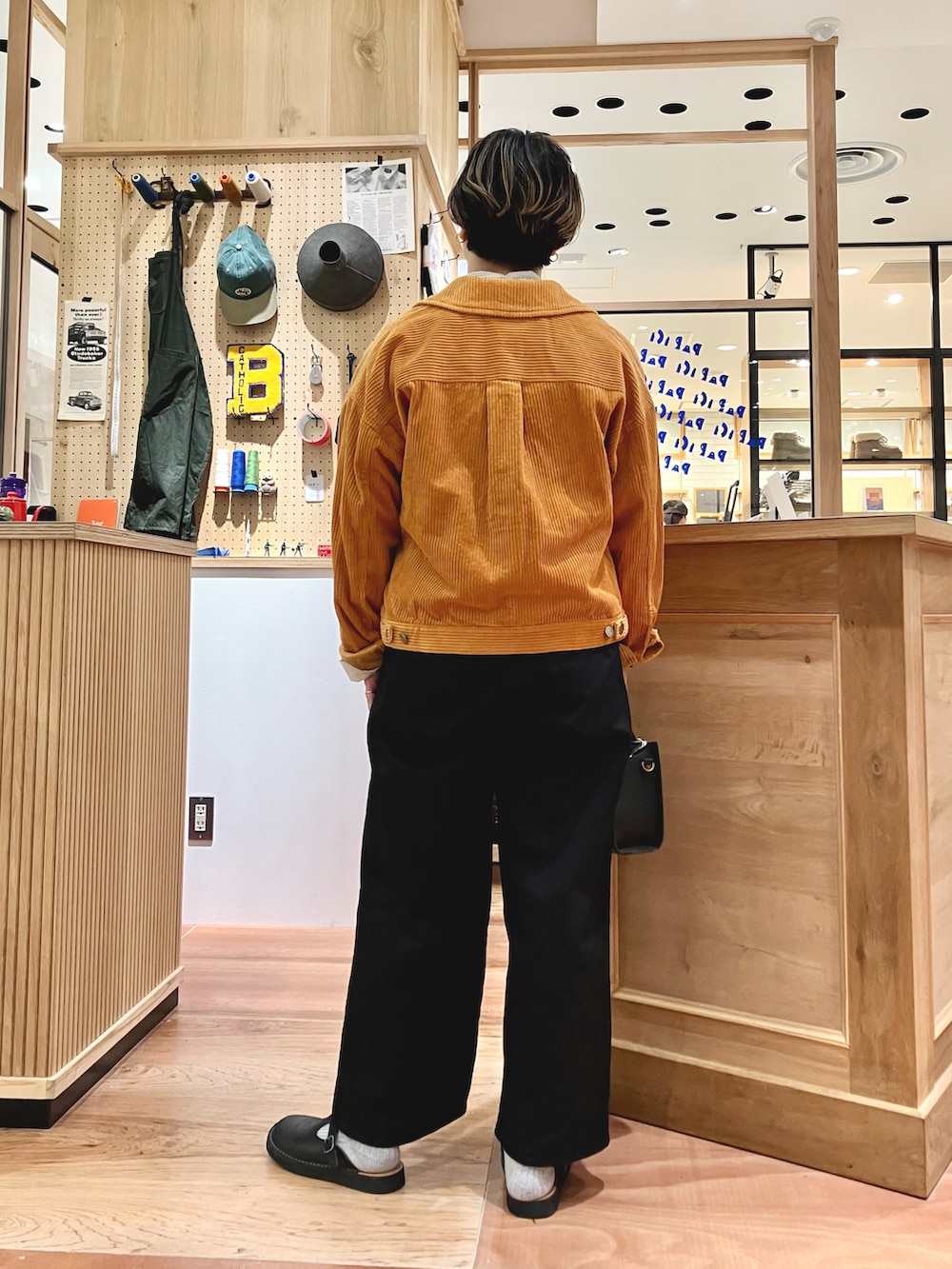オレンジ系のブルゾン、ベージュ系のシャツ/ブラウス、ブラック系のその他パンツを着用したレディースの秋コーディネートの3枚目の写真