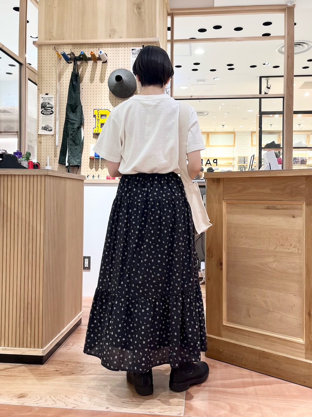 ホワイト系のTシャツ/カットソー、ホワイト系のショルダーバッグ、ブラック系のスカートを着用したレディースの夏コーディネートの3枚目の写真