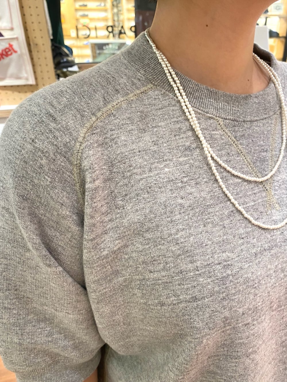 ブルー系のスカート、グレー系のTシャツ/カットソー、ホワイト系のネックレスを着用したレディースの夏コーディネートの4枚目の写真