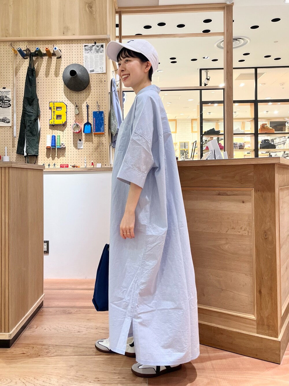 ブルー系のシャツワンピース、ブルー系のトートバッグを着用したレディースの夏コーディネートの3枚目の写真