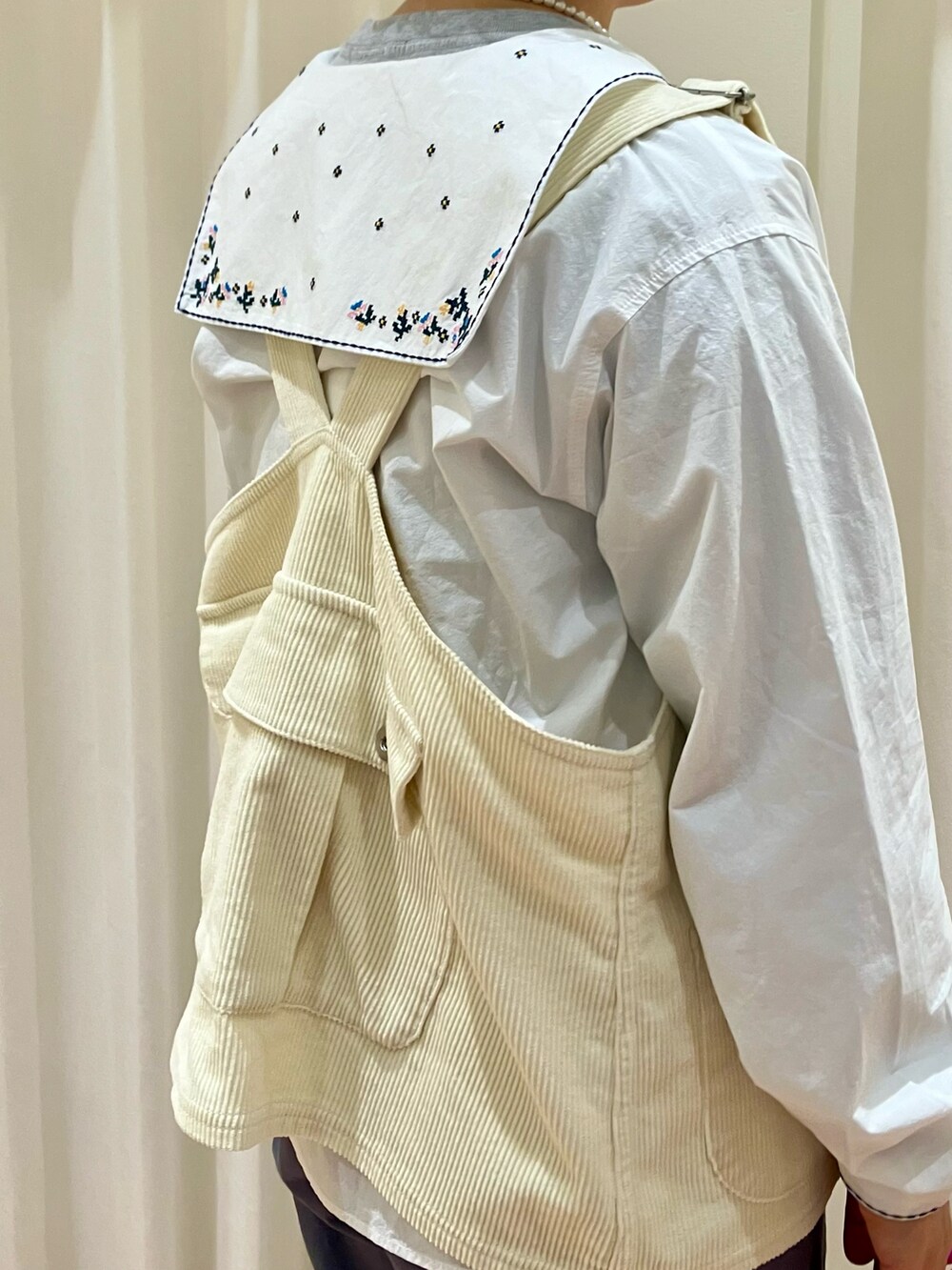 ホワイト系のシャツ/ブラウス、グレー系のTシャツ/カットソー、ホワイト系のベストを着用したレディースの冬コーディネートの4枚目の写真