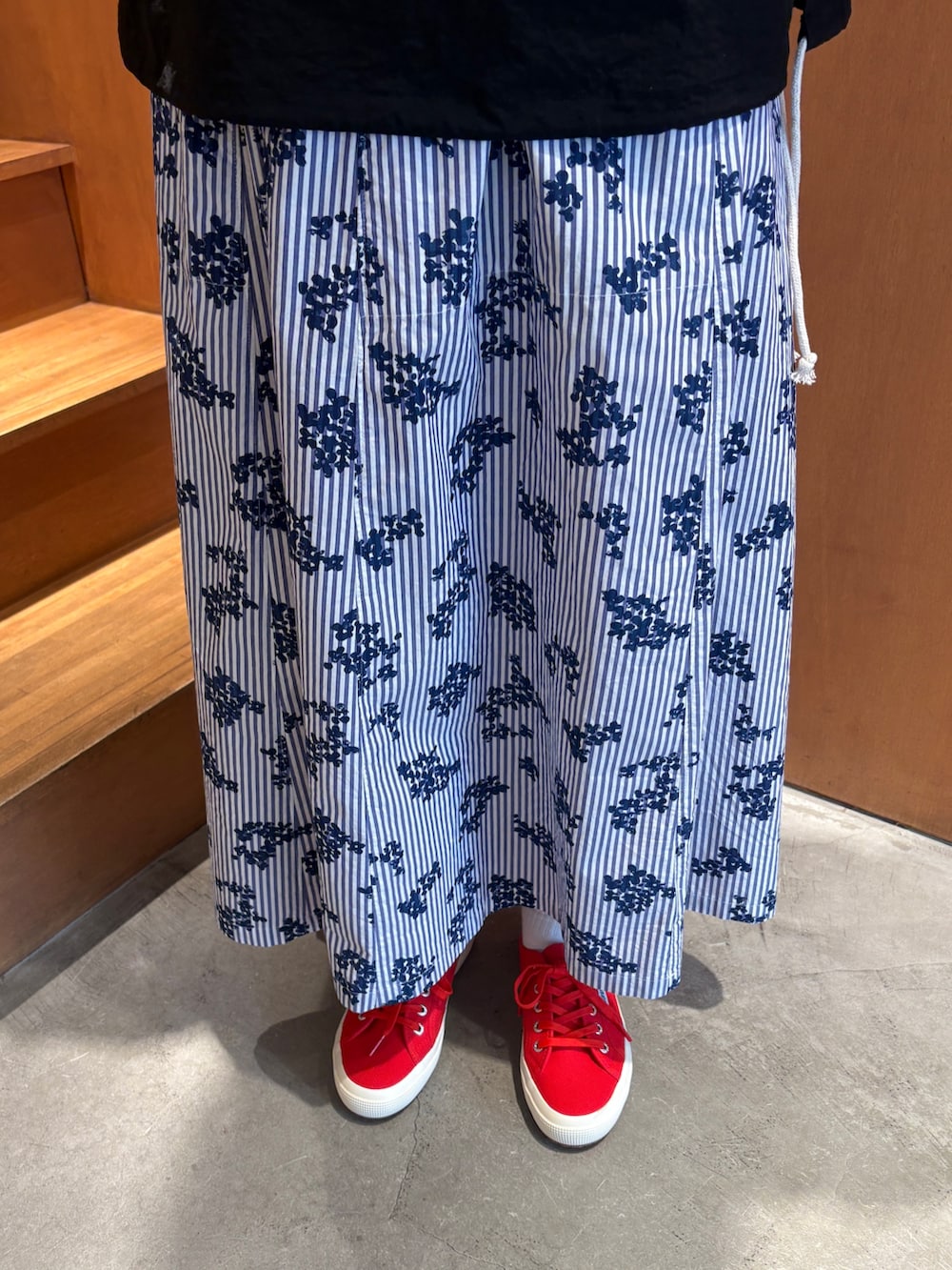 ホワイト系のTシャツ/カットソー、ブラック系のその他アウター、ブルー系のスカートを着用したレディースの春コーディネートの8枚目の写真