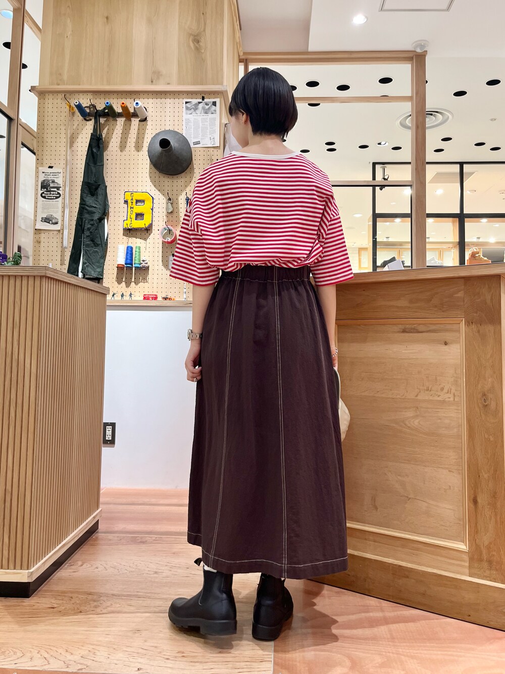 レッド系のTシャツ/カットソー、ブラウン系のスカートを着用したレディースの夏コーディネートの2枚目の写真