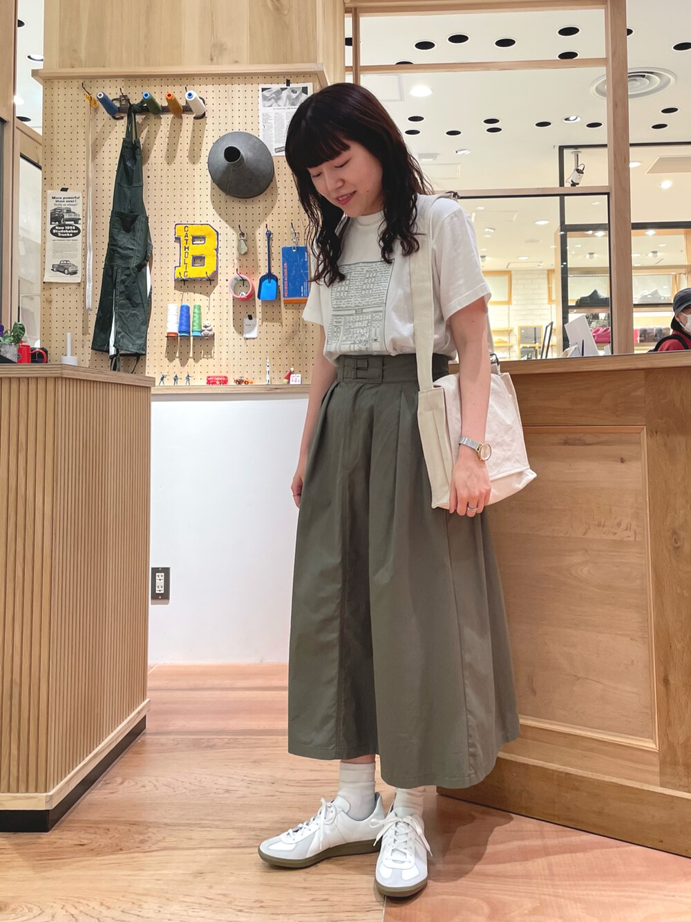 ホワイト系のTシャツ/カットソー、ベージュ系のカーディガン/ボレロ、ホワイト系のショルダーバッグを着用したレディースの春コーディネートの5枚目の写真