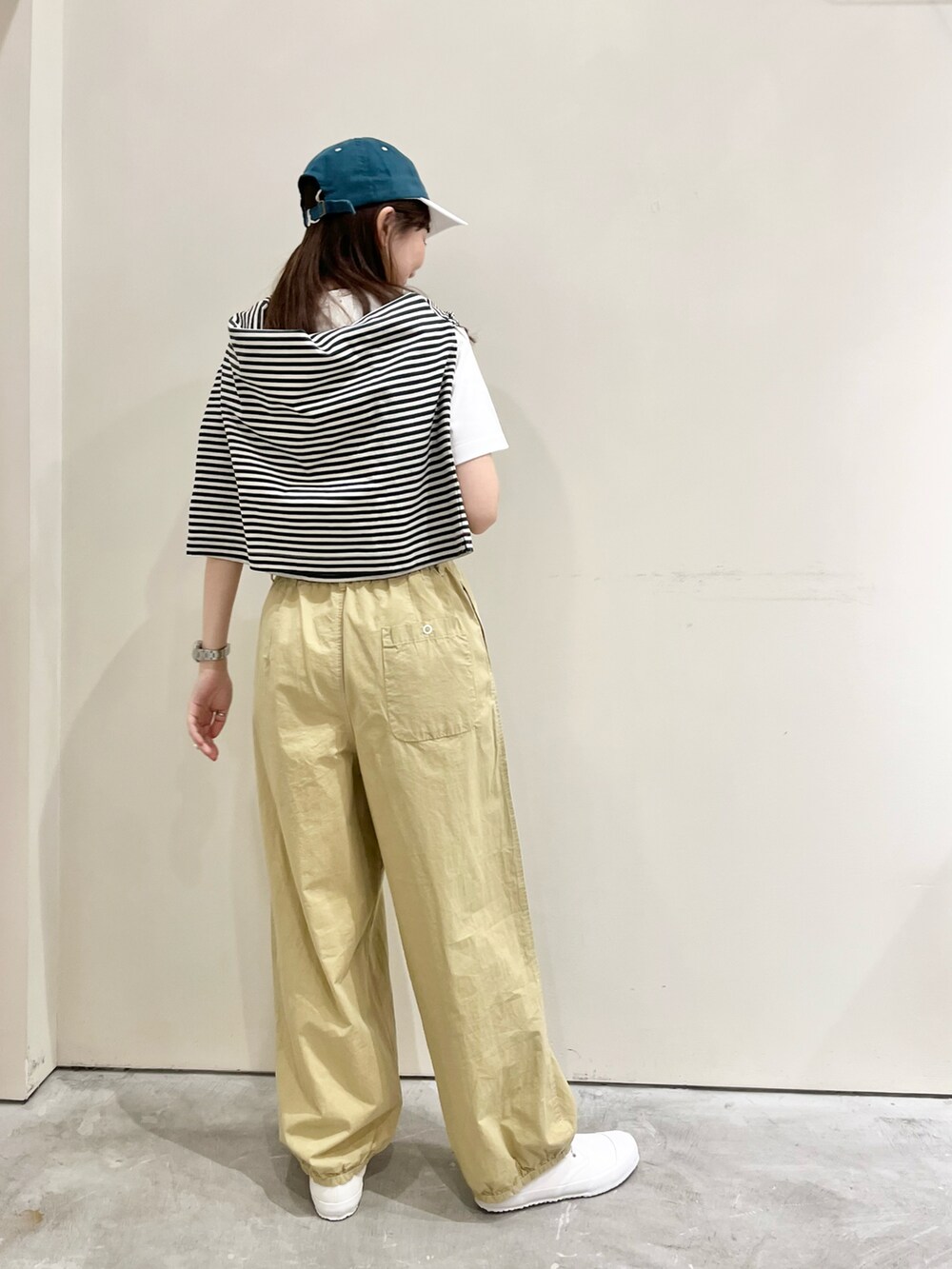 ホワイト系のTシャツ/カットソー、ベージュ系のその他パンツ、ホワイト系のスニーカーを着用したレディースの春コーディネートの3枚目の写真