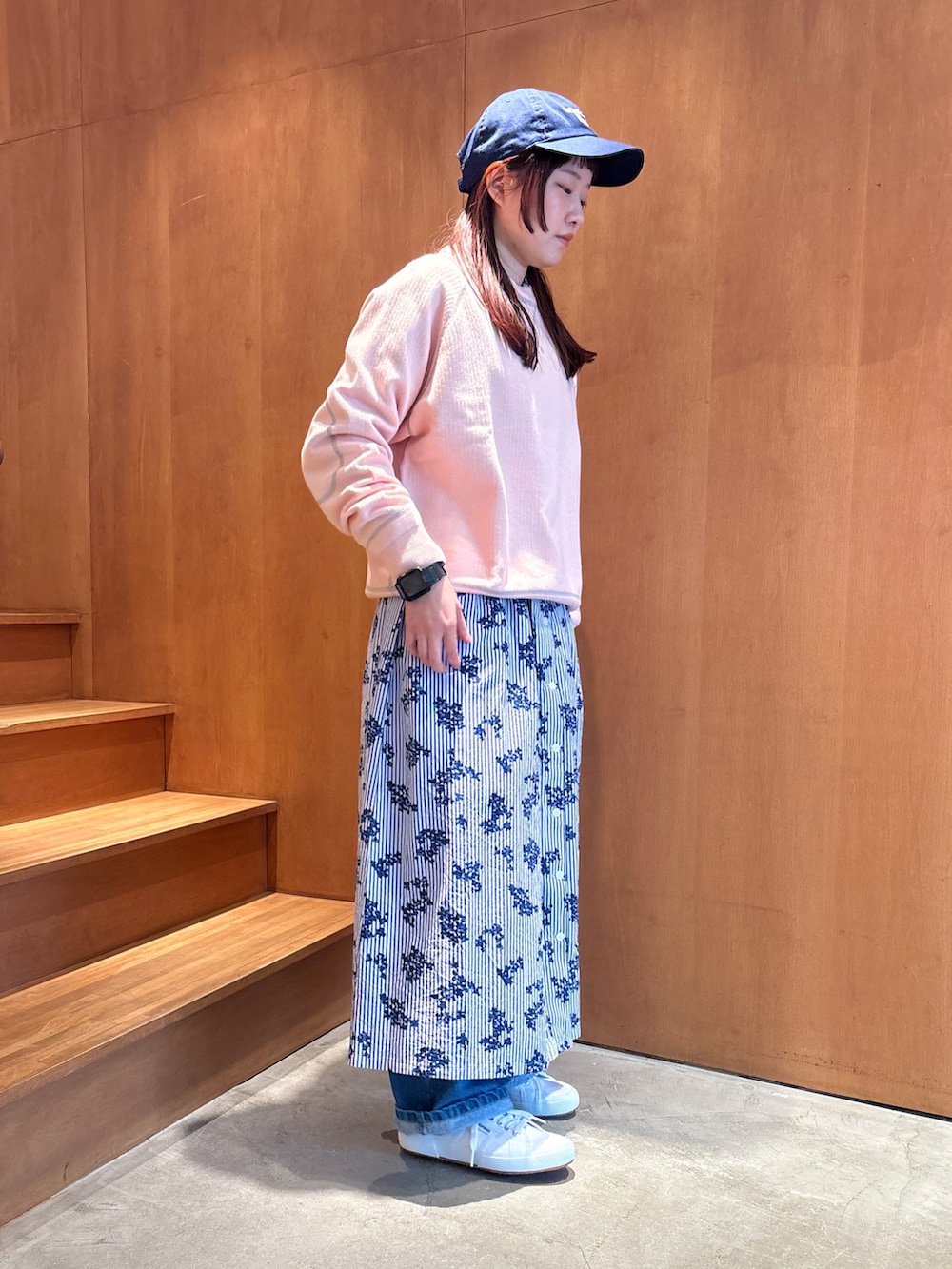 ピンク系のニット/セーター、ブルー系のワンピースを着用したレディースの春コーディネートの2枚目の写真