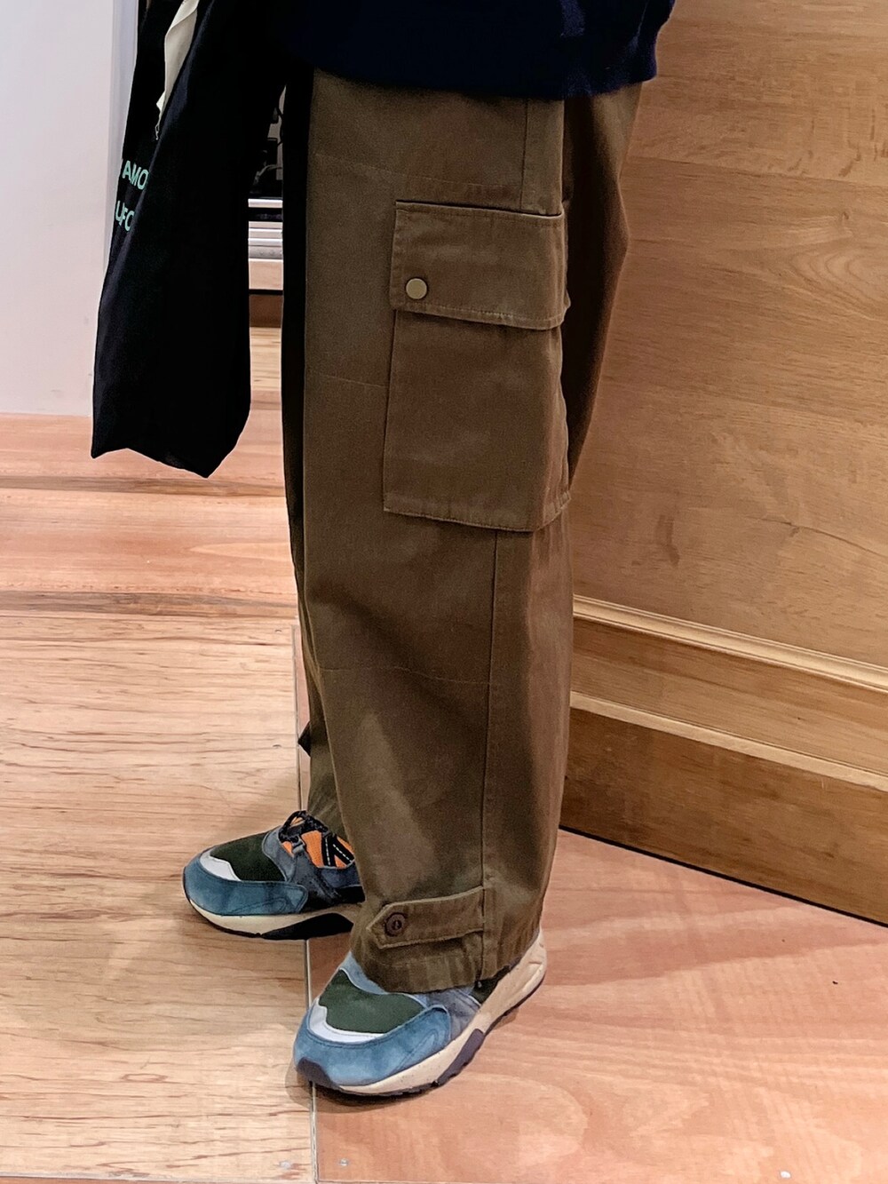 イエロー系のTシャツ/カットソー、ブルー系のカーディガン/ボレロ、グリーン系のカーゴパンツを着用したレディースの冬コーディネートの5枚目の写真