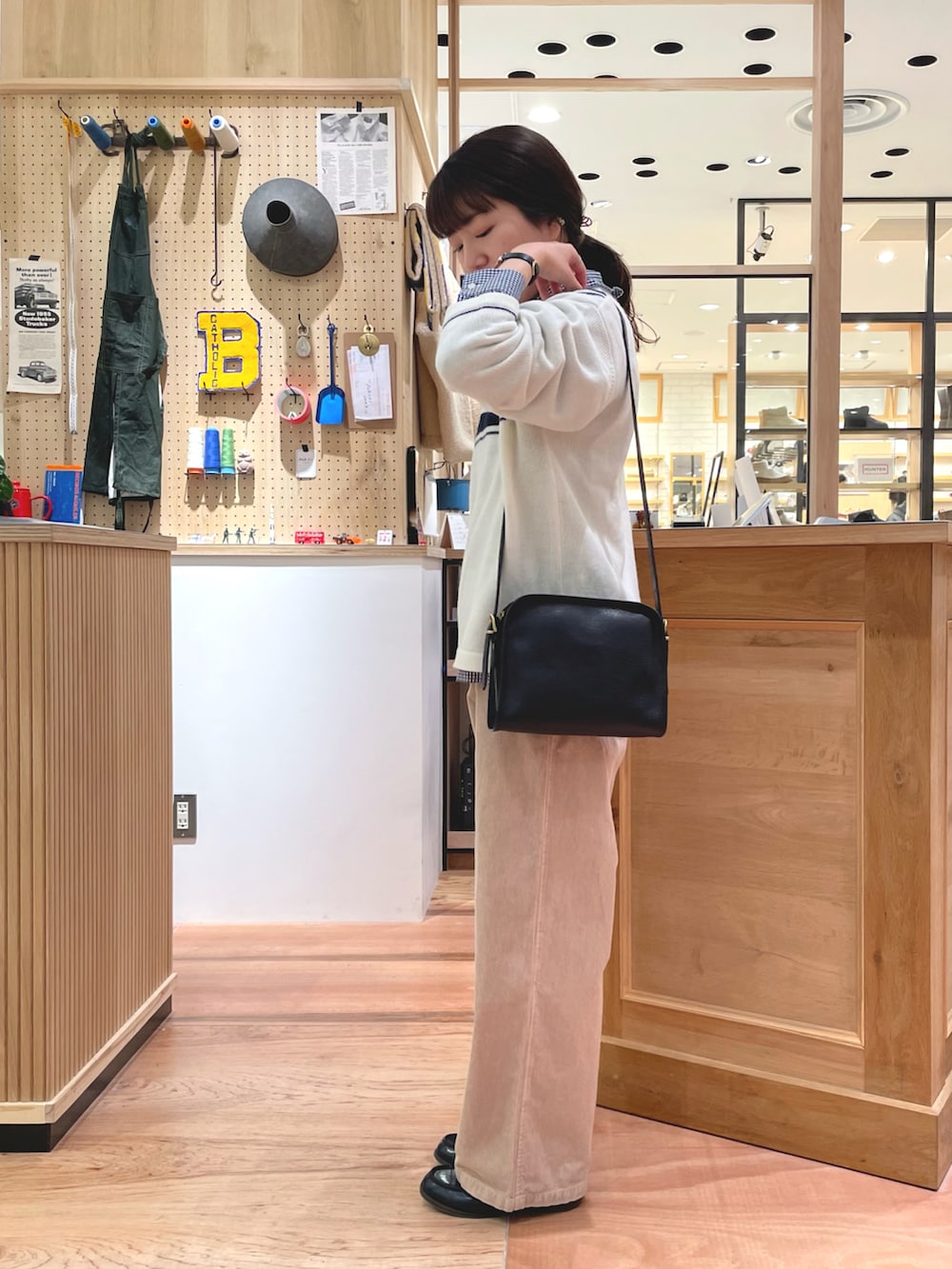 ブラック系のショルダーバッグ、ブルー系のダッフルコート、ベージュ系のその他パンツを着用したレディースの冬コーディネートの4枚目の写真