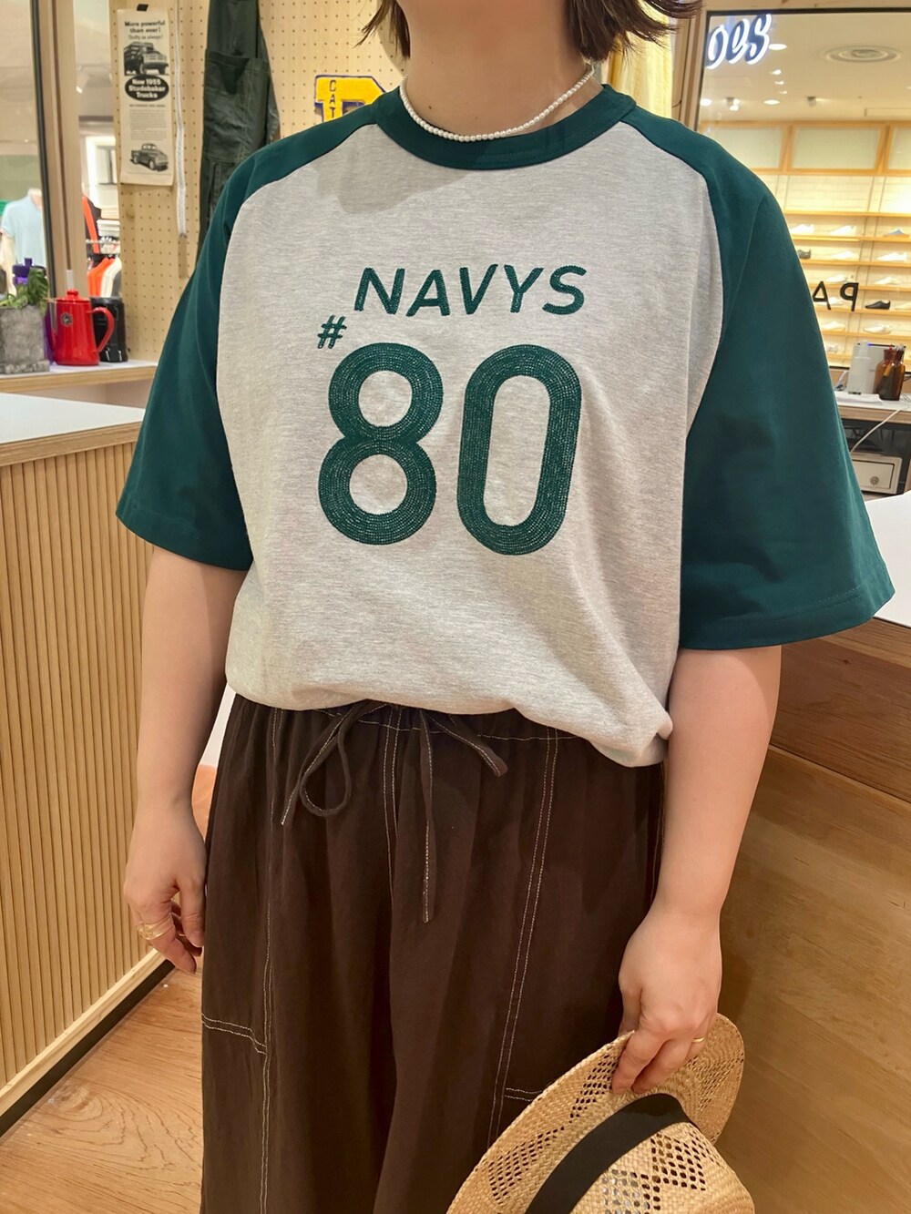 グリーン系のTシャツ/カットソー、ブラウン系のスカートを着用したレディースの夏コーディネートの2枚目の写真