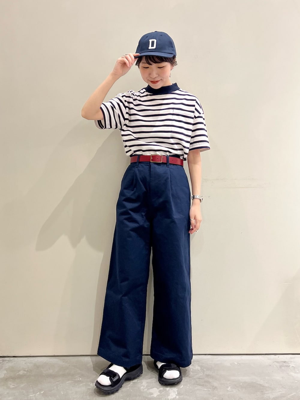 ホワイト系のTシャツ/カットソー、ブルー系のチノパンツ、レッド系のベルトを着用したレディースの春コーディネートの2枚目の写真