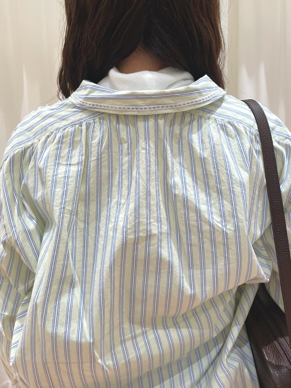 イエロー系のシャツ/ブラウス、グレー系のスカート、ホワイト系のTシャツ/カットソーを着用したレディースの冬コーディネートの5枚目の写真