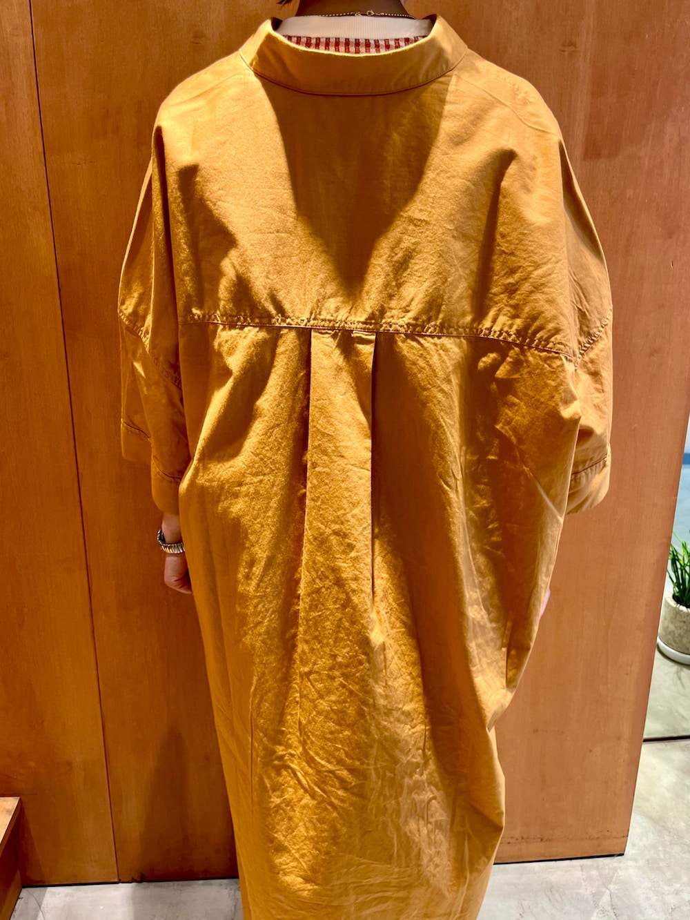 オレンジ系のシャツワンピース、オレンジ系のTシャツ/カットソー、ホワイト系のトートバッグを着用したレディースの夏コーディネートの4枚目の写真