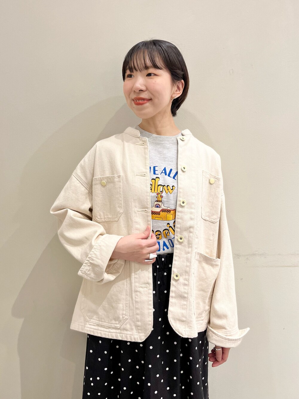 ホワイト系のカバーオール、ブラック系のスカート、グレー系のTシャツ/カットソーを着用したレディースの春コーディネートの4枚目の写真