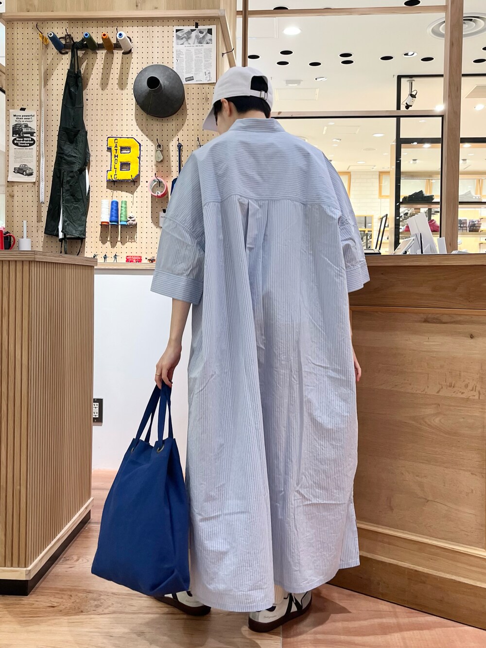 ブルー系のシャツワンピース、ブルー系のトートバッグを着用したレディースの夏コーディネートの4枚目の写真