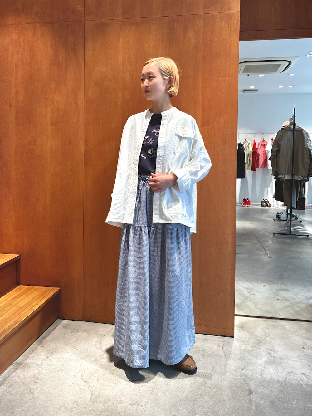 ホワイト系のシャツ/ブラウス、ブルー系のスカート、ベージュ系のモカシン/デッキシューズを着用したレディースの夏コーディネートの2枚目の写真