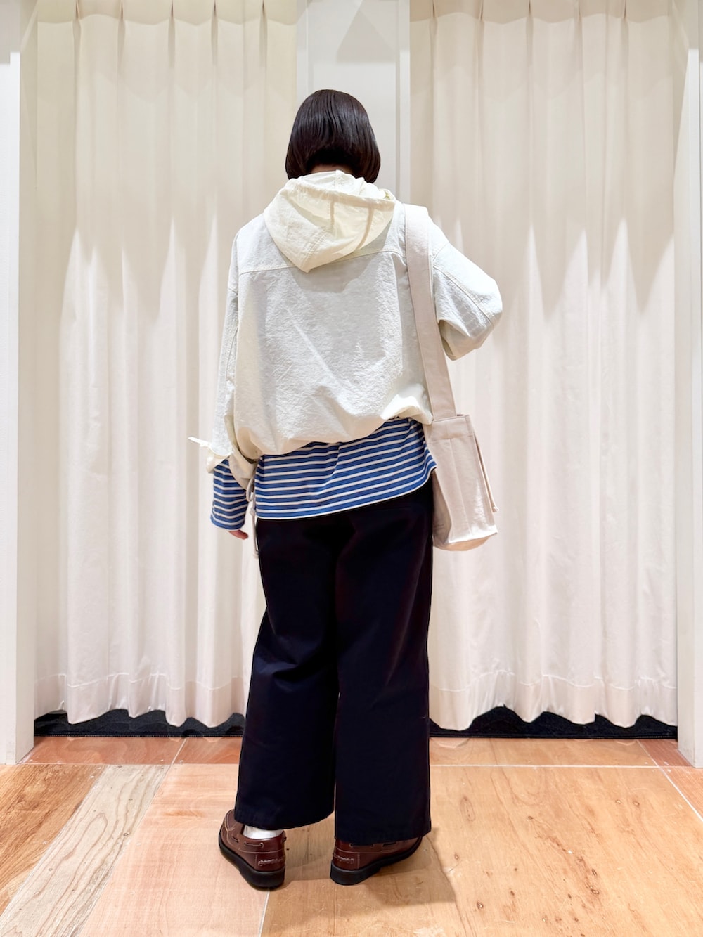 ホワイト系のその他アウター、ブルー系のチノパンツ、ホワイト系のショルダーバッグを着用したレディースの春コーディネートの2枚目の写真