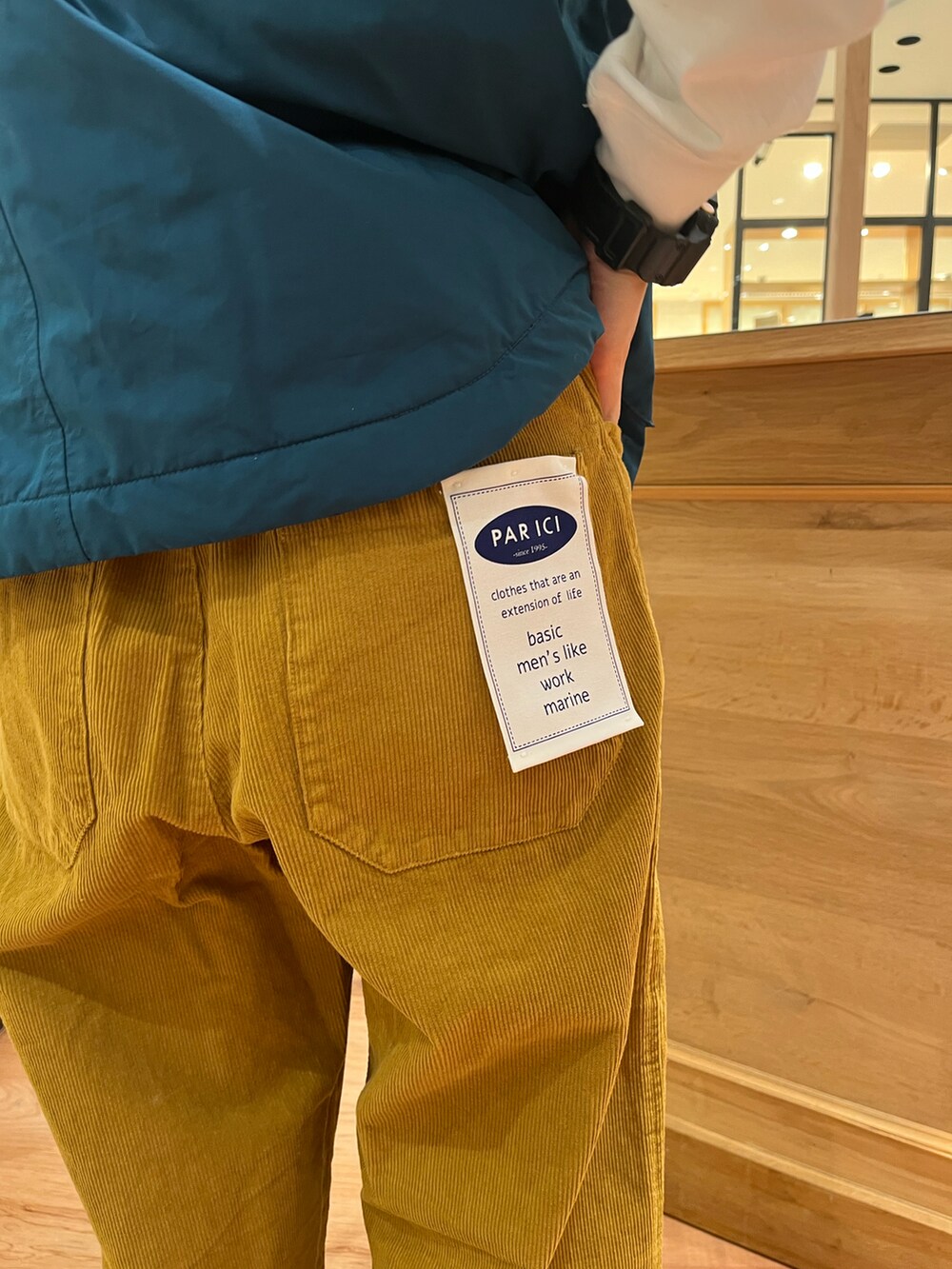 グリーン系のダウンベスト、イエロー系のその他パンツ、ホワイト系のTシャツ/カットソーを着用したレディースの秋コーディネートの5枚目の写真