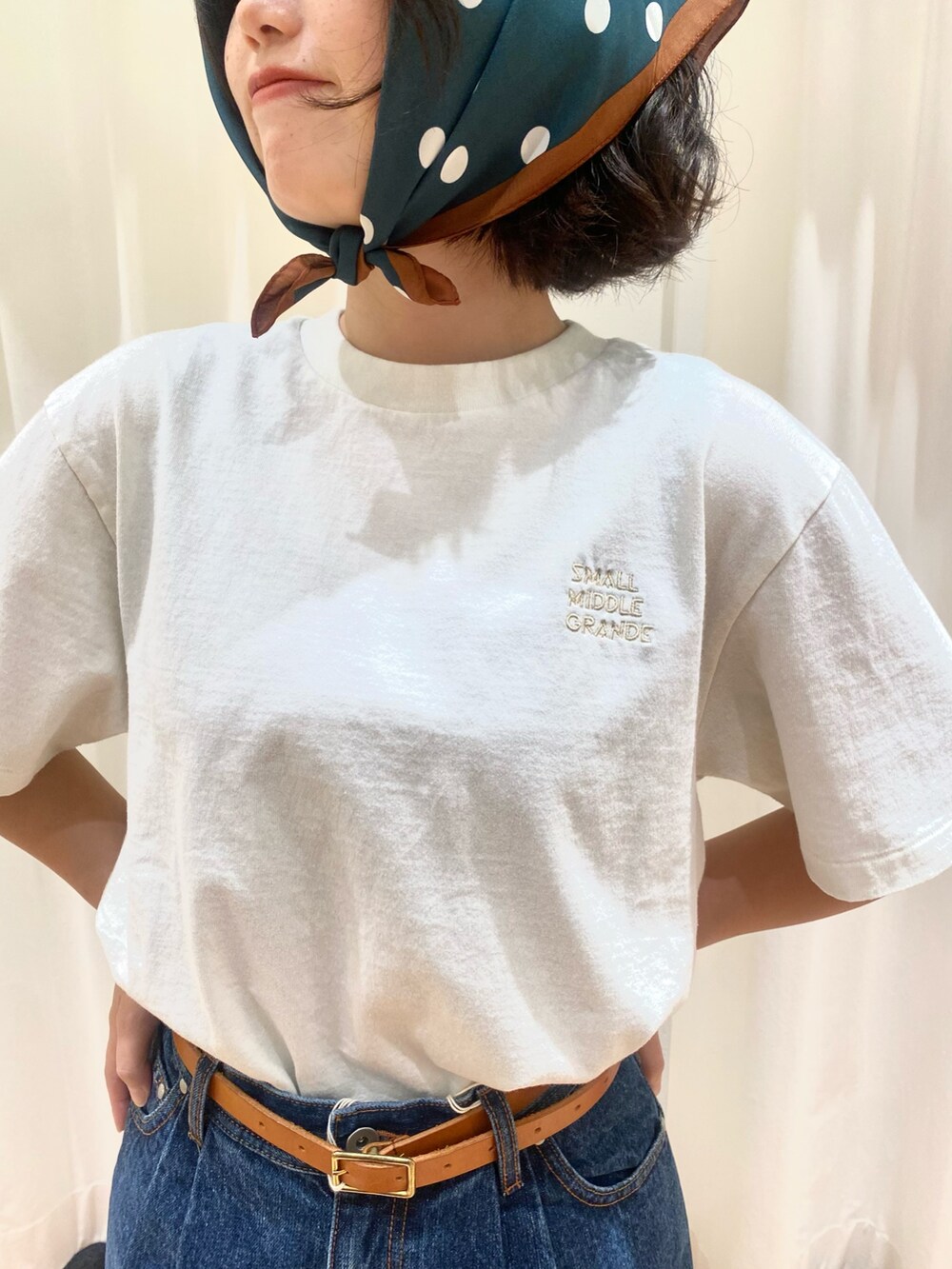ブルー系のデニムパンツ、ホワイト系のTシャツ/カットソー、ブラウン系のベルトを着用したレディースの夏コーディネートの4枚目の写真