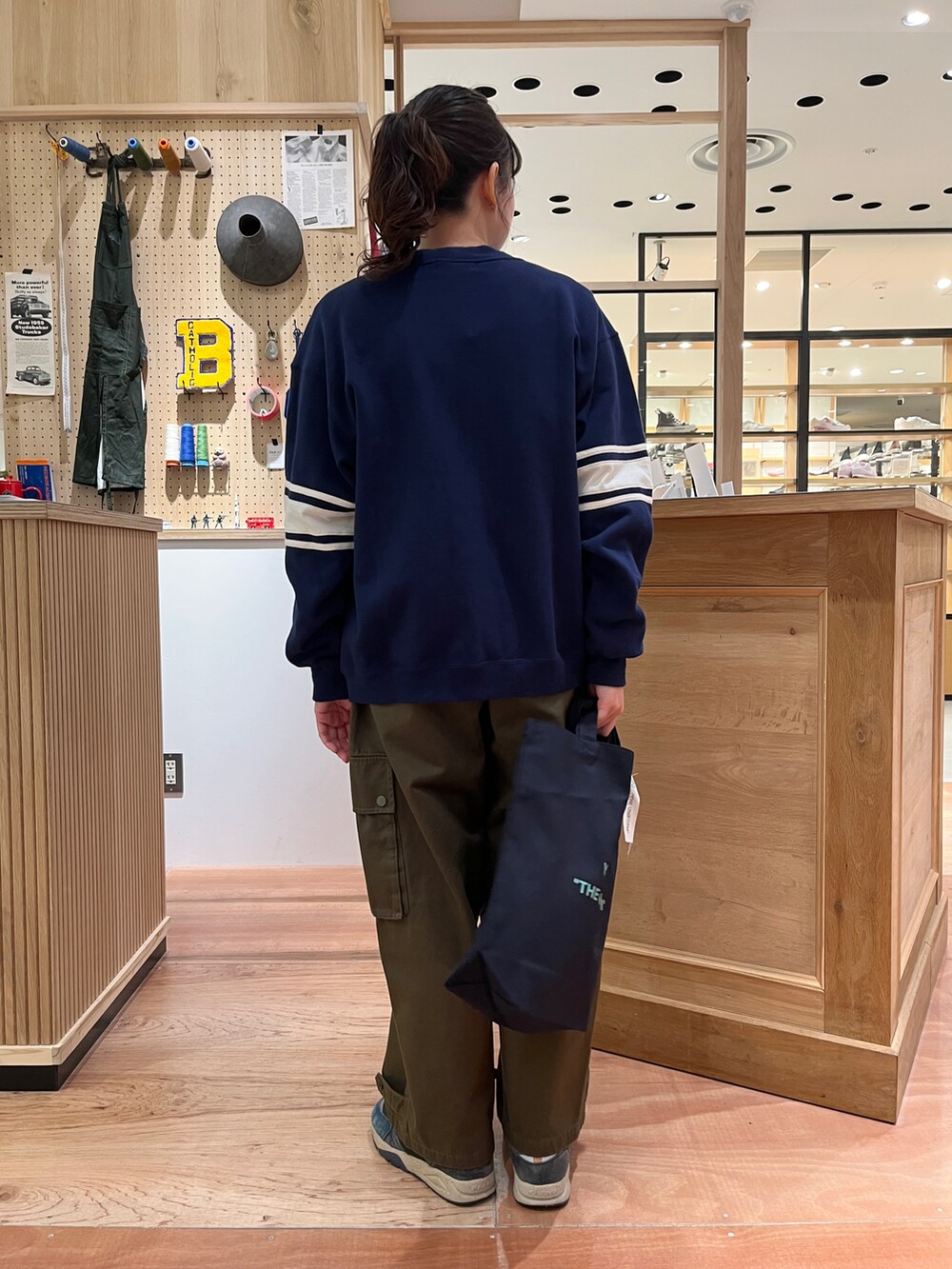 イエロー系のTシャツ/カットソー、ブルー系のカーディガン/ボレロ、グリーン系のカーゴパンツを着用したレディースの冬コーディネートの3枚目の写真