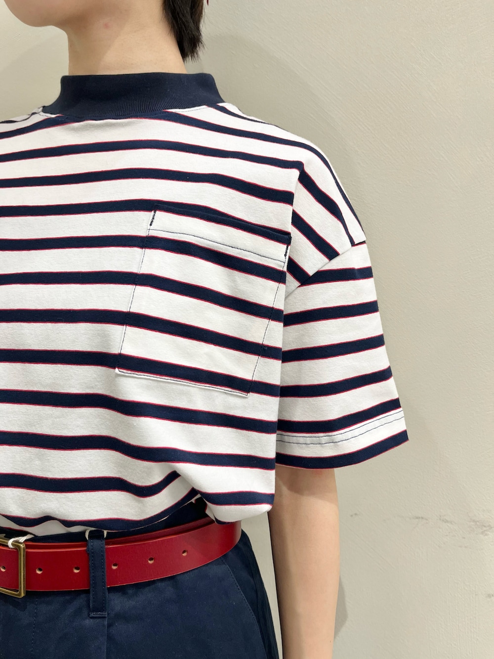 ホワイト系のTシャツ/カットソー、ブルー系のチノパンツ、レッド系のベルトを着用したレディースの春コーディネートの4枚目の写真