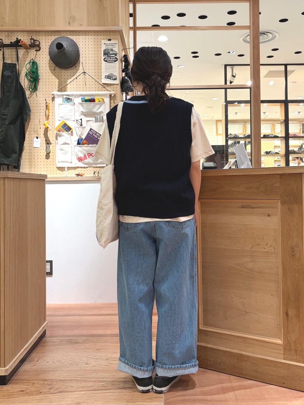 ブルー系のベスト、ホワイト系のTシャツ/カットソー、ブルー系のデニムパンツを着用したレディースの春コーディネートの4枚目の写真