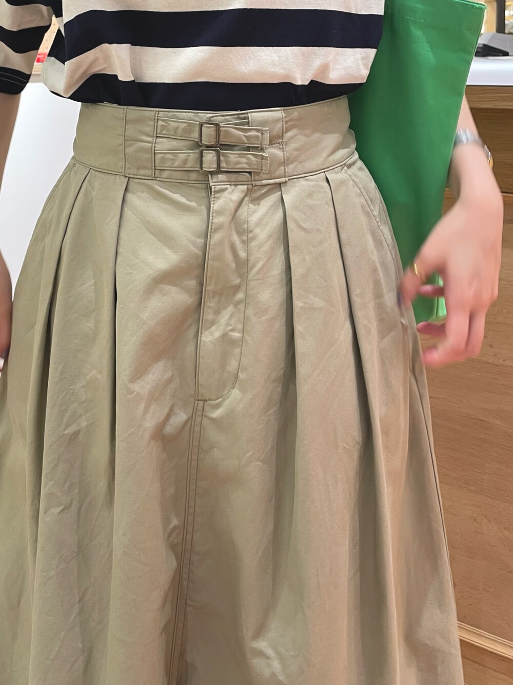 ベージュ系のスカート、ブルー系のTシャツ/カットソーを着用したレディースの春コーディネートの4枚目の写真