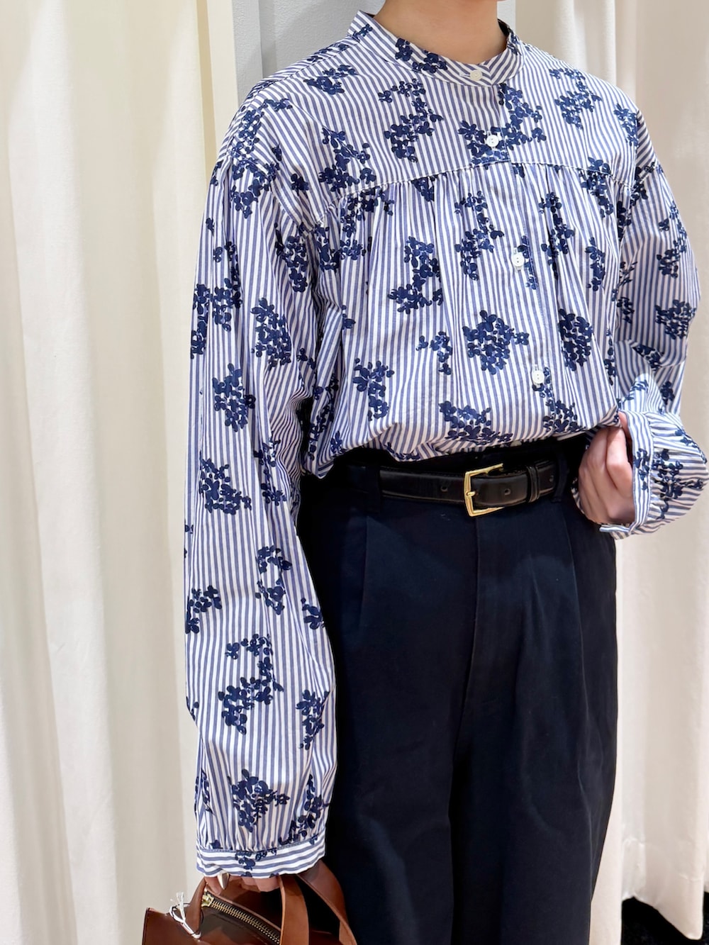 ブルー系のシャツ/ブラウス、ブルー系のチノパンツ、ブラウン系のショルダーバッグを着用したレディースの春コーディネートの3枚目の写真