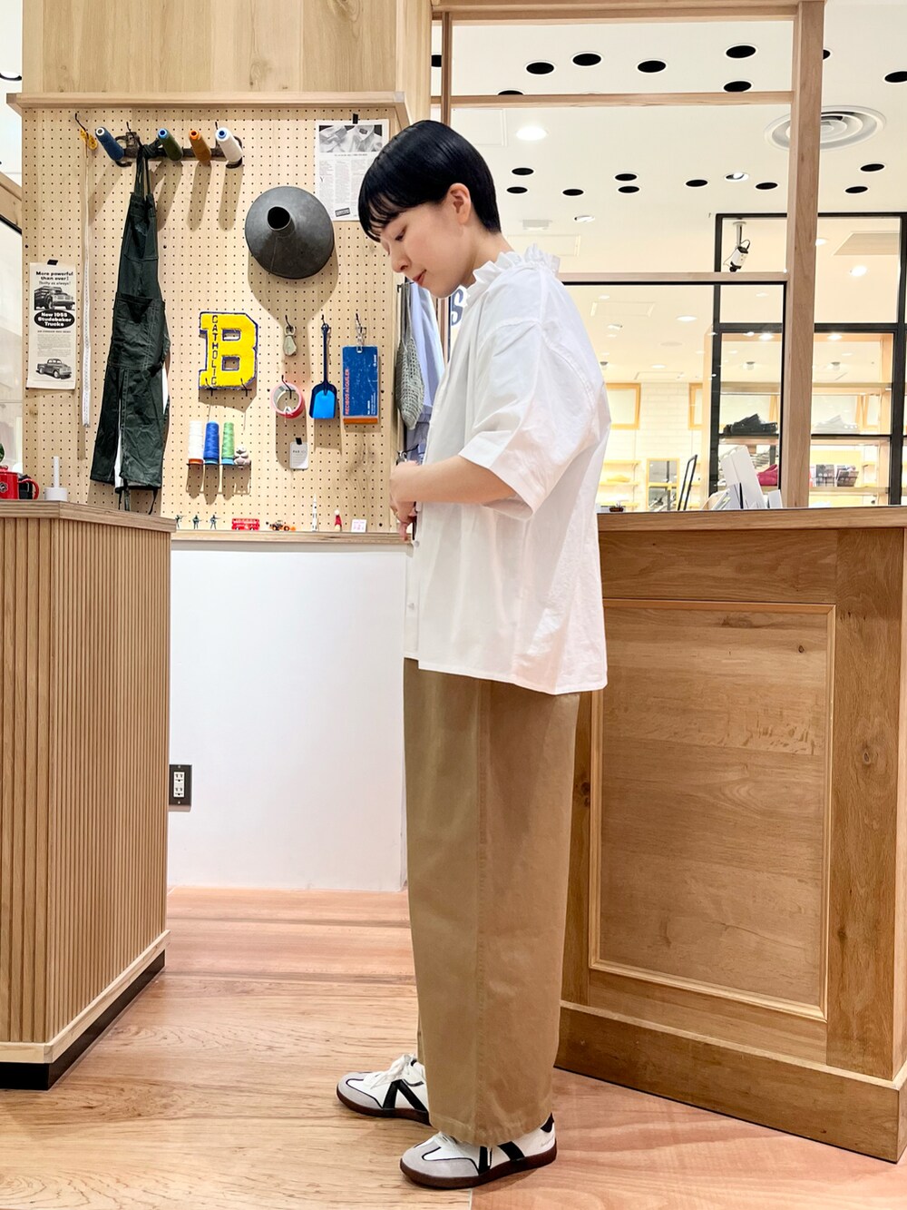 ホワイト系のシャツ/ブラウス、ブルー系のTシャツ/カットソー、ベージュ系のチノパンツを着用したレディースの夏コーディネートの2枚目の写真