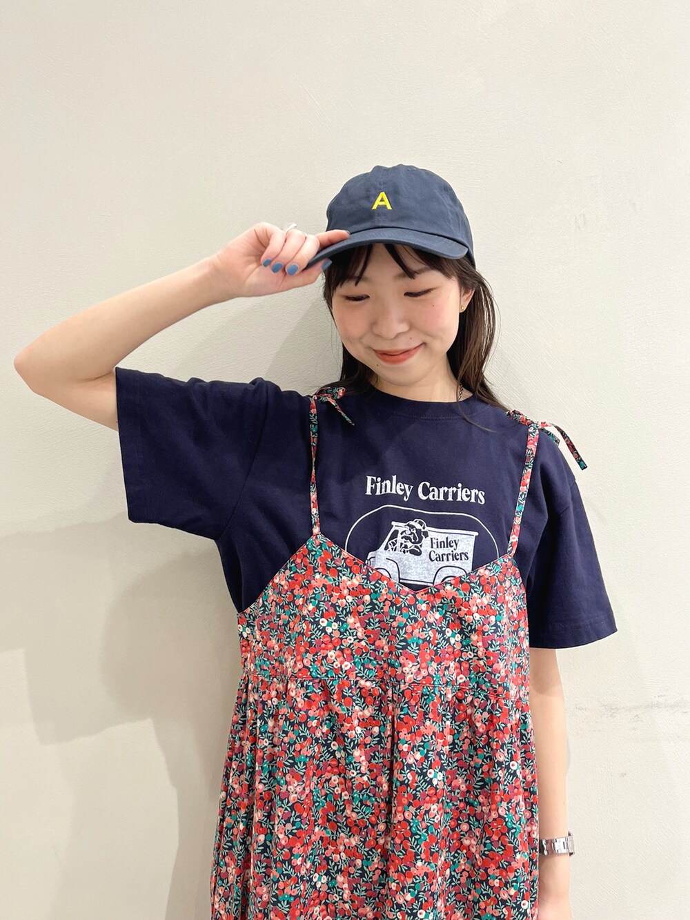ブルー系のTシャツ/カットソー、レッド系のワンピース、ブルー系のキャップを着用したレディースの春コーディネートの4枚目の写真