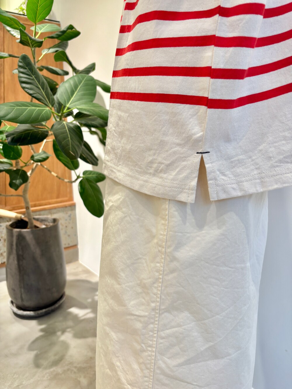 レッド系のTシャツ/カットソー、ホワイト系のスカート、グリーン系のキャップを着用したレディースの夏コーディネートの5枚目の写真