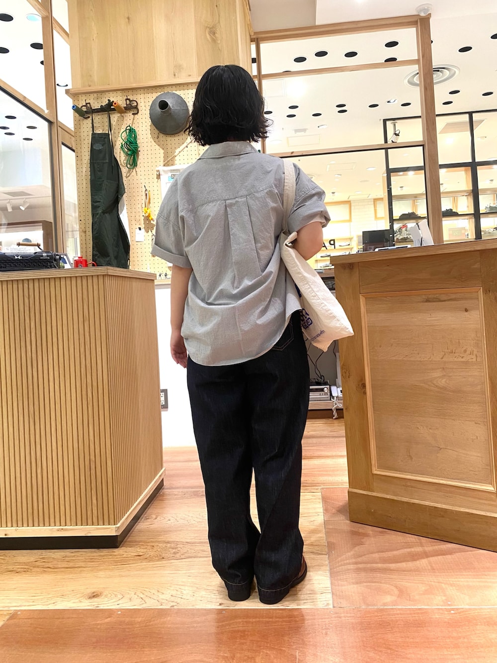 グレー系のシャツ/ブラウス、ブルー系のデニムパンツ、ブラウン系のモカシン/デッキシューズを着用したレディースの夏コーディネートの3枚目の写真