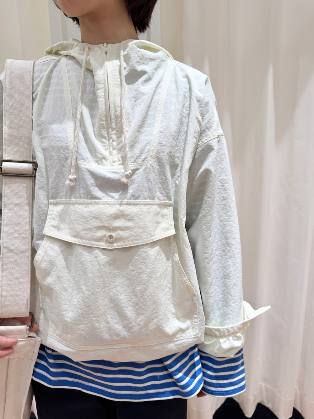 ホワイト系のその他アウター、ブルー系のチノパンツ、ホワイト系のショルダーバッグを着用したレディースの春コーディネートの4枚目の写真